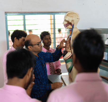 teacher explaining human anatomy using a dummy model